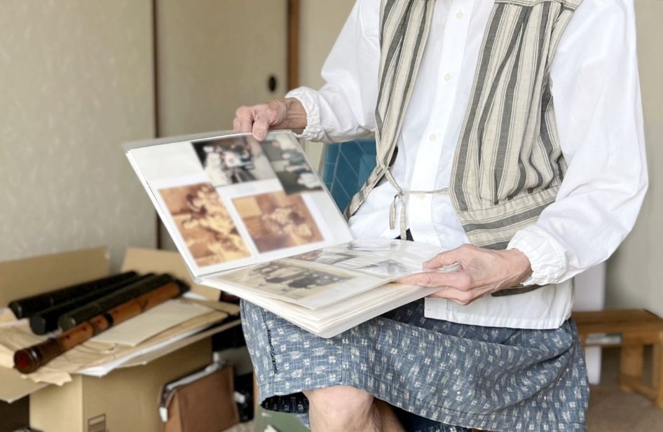 断捨離をしながら古いアルバムをめくる高齢女性