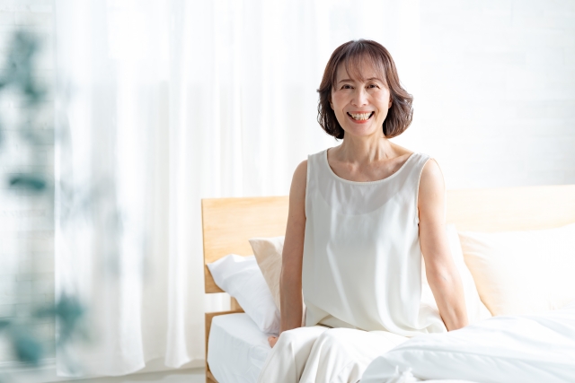 明るく前向きな気持ちで目覚めて起き上がるシニア女性